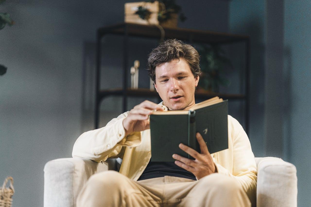 Osoba czytająca książkę w fotelu